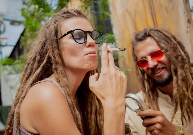 Couple enjoying Lemon Skunk cannabis outdoors in a relaxed, social setting